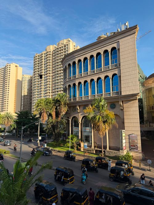 Free City street scene with auto rickshaws and grand buildings, lively atmosphere. Stock Photo