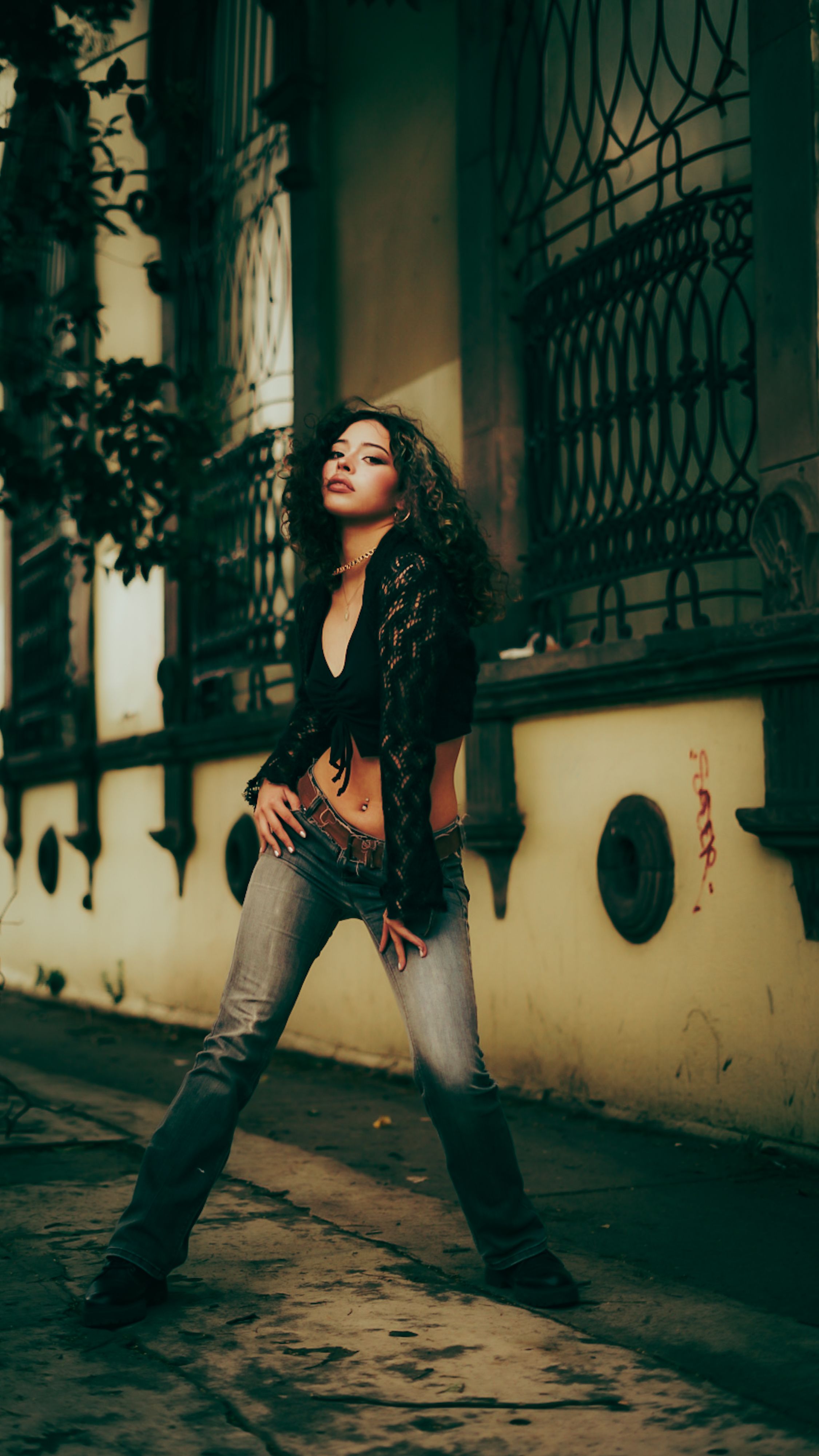 Stylish woman posing confidently in an artistic urban environment with moody lighting.