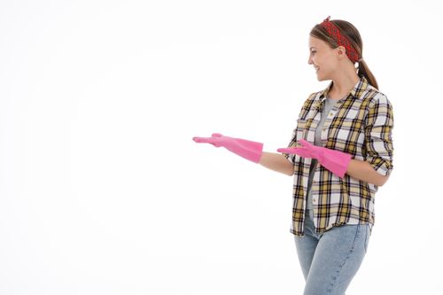 Free Smiling woman in a plaid shirt and pink gloves, posing against a white background. Stock Photo