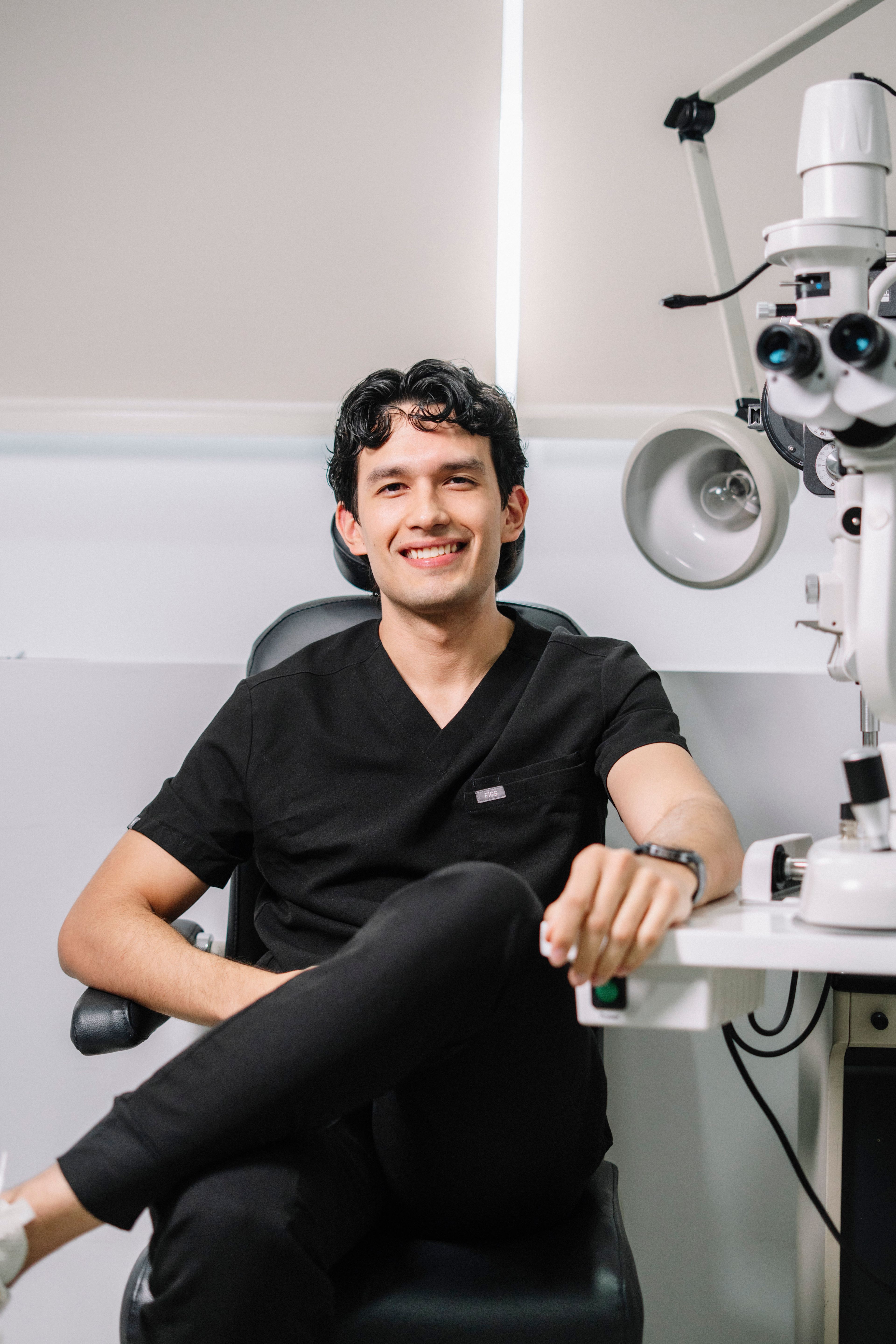 Nadia beside the slit lamp in the exam room