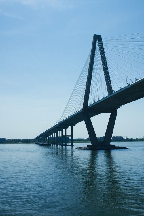 Free Wide angle view of the Arthur Ravenel Jr. Bridge over calm water under clear blue skies. Stock Photo