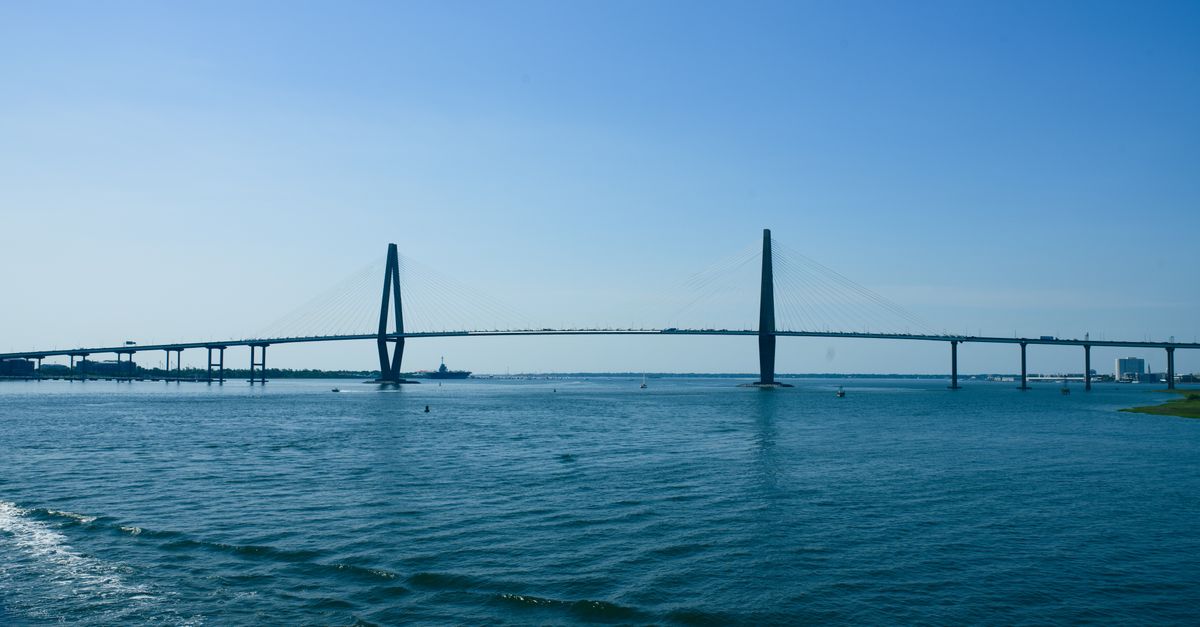 Scenic view of the Arthur Ravenel Jr. Bridge over calm blue waters under a clear sky.