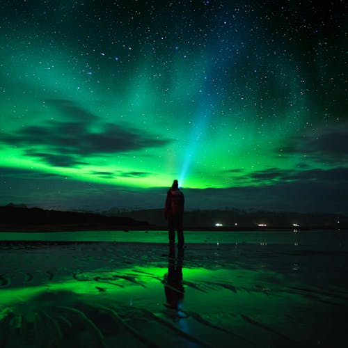 Persona In Piedi Sul Campo Di Erba Verde Sotto Il Cielo Verde Con Le Stelle Durante La Notte