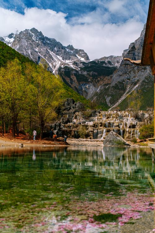 Free A picturesque mountain scene with a tranquil lake and vibrant spring blossoms. Stock Photo
