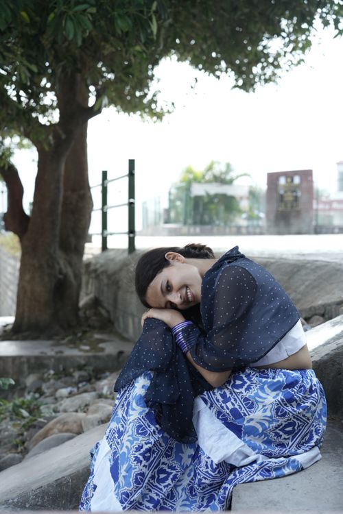 Free A young woman in blue traditional attire sitting outdoors under a tree, exuding tranquility. Stock Photo