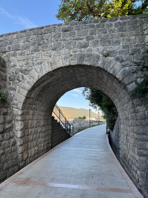Free Scenic view through a stone archway in Herceg Novi, Montenegro showcasing a tranquil pathway. Stock Photo