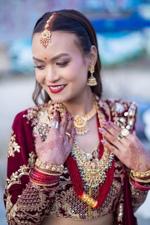 Free Beautiful bride in ornate Indian outfit with intricate henna and jewelry, smiling gracefully. Stock Photo