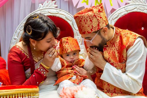 Free A family in vibrant traditional attire celebrates a joyful occasion indoors. Stock Photo