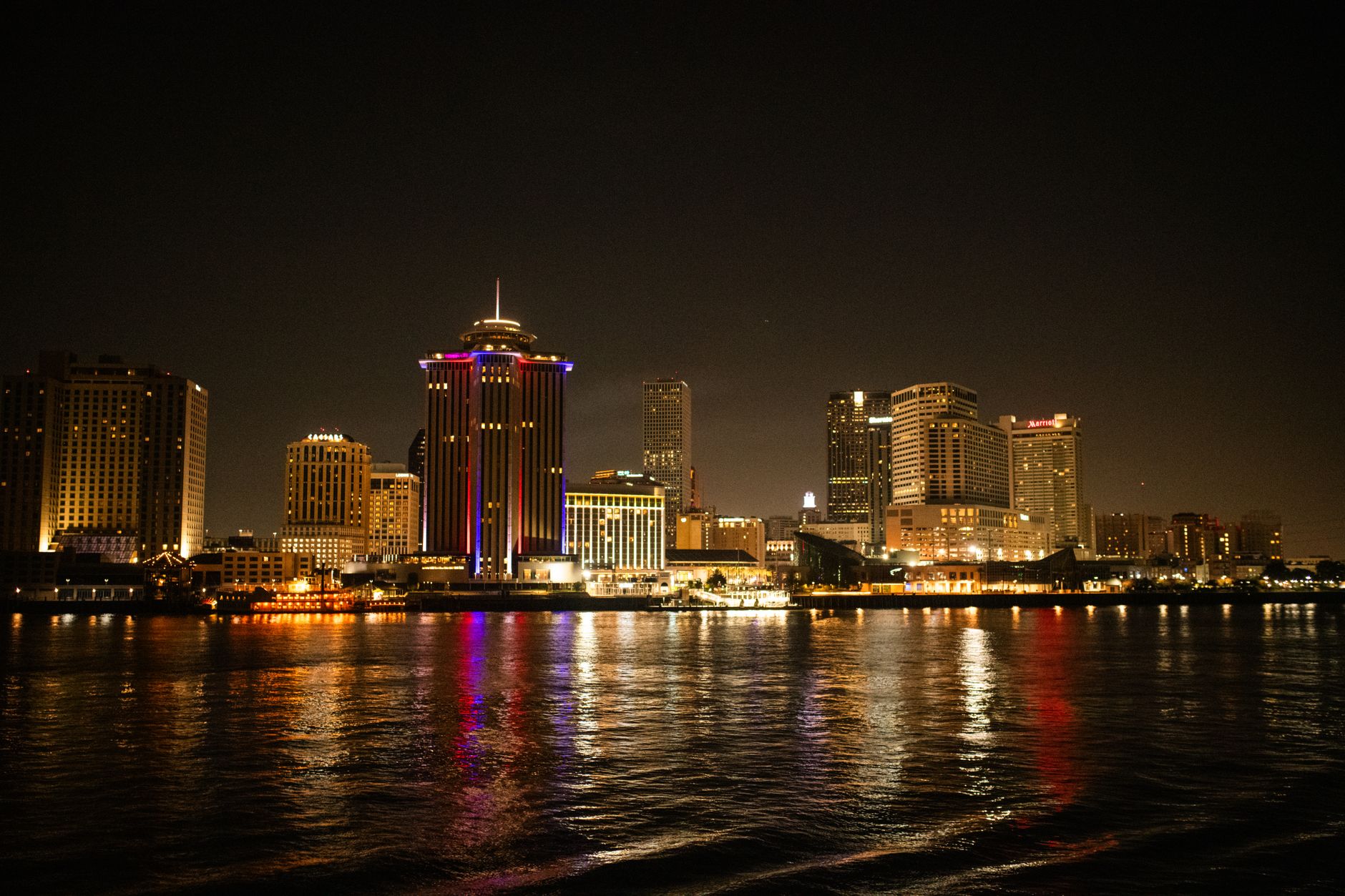 Door hanger delivery in New Orleans, LA Door hanger distribution and flyer delivery in New Orleans, LA — Captivating night shot of New Orleans skyline reflecting on the Mississippi River. above neighborhoods DoorBlitz crews walk