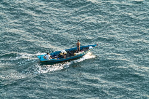 Free People Riding on Blue Boat on Sea Stock Photo