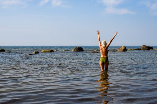 Free Woman enjoying the summer at Suurupi Beach, Estonia, arms raised in serenity and freedom. Stock Photo