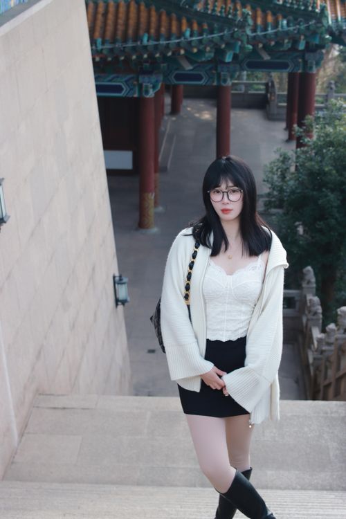 Free A stylish woman poses on steps in Nanjing, featuring traditional Chinese architecture. Stock Photo