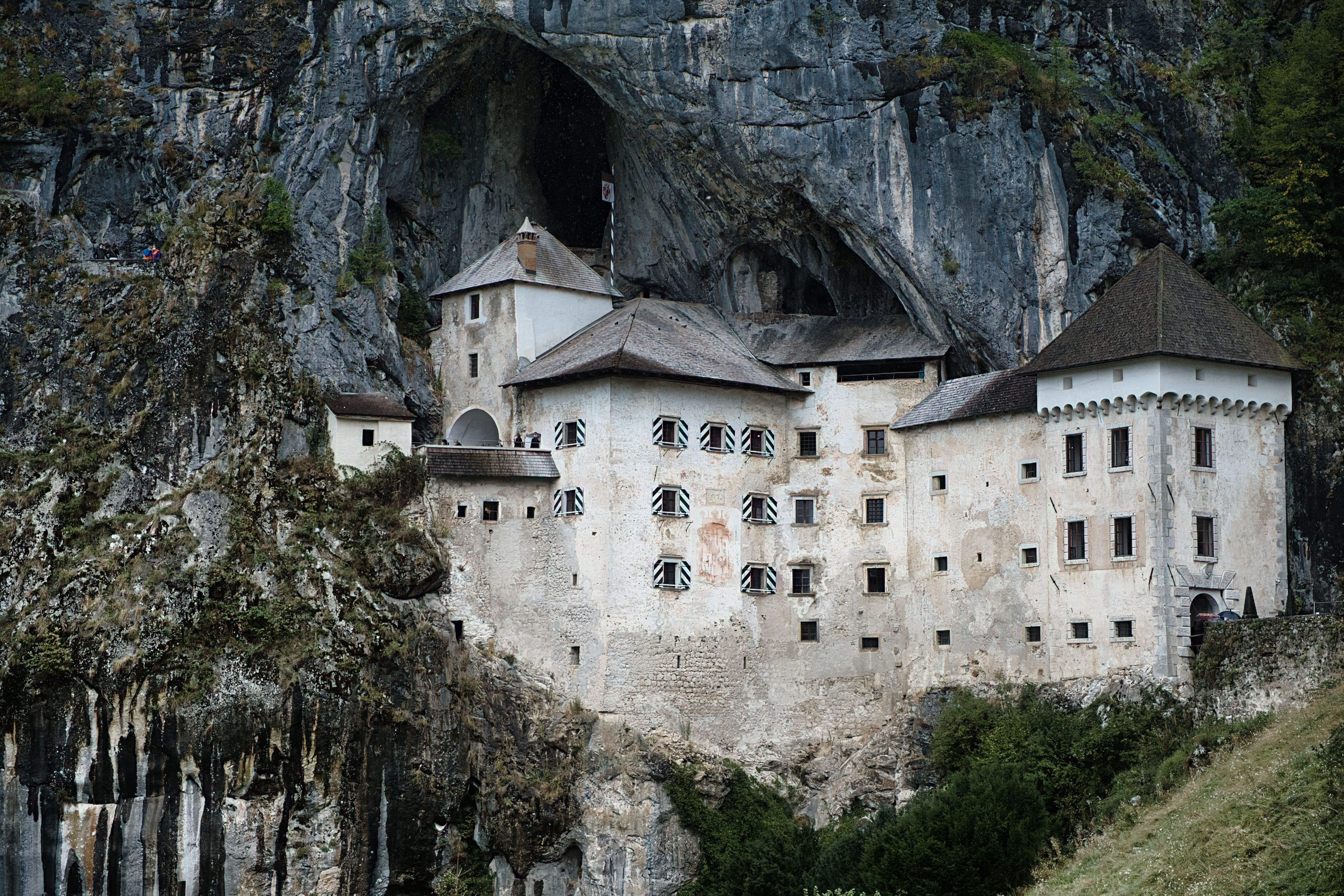 Predjama Castle Nestled In A Dramatic Cliff Face In Slovenia, A Unique Renaissance Fortress.