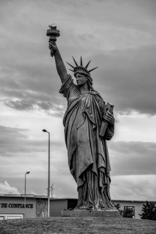 Free Black and white photo of a Liberty statue replica under cloudy skies in Colmar, France. Stock Photo