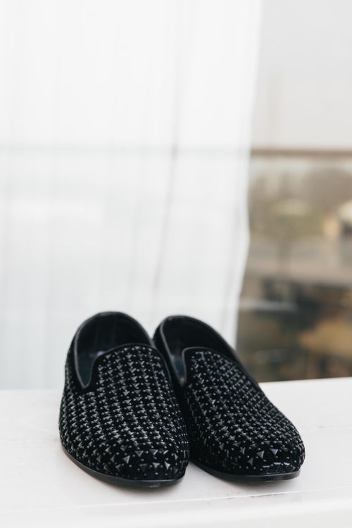 Free Stylish black loafers with a textured pattern on a minimalist white surface. Perfect for fashion and lifestyle themes. Stock Photo