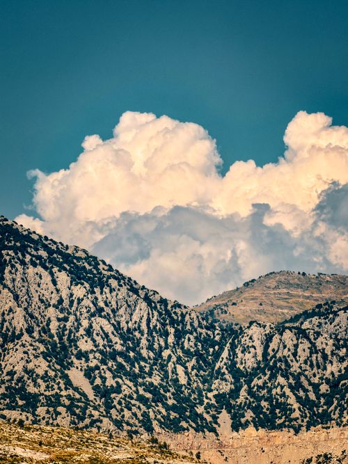 Free Stunning view of a majestic mountain range with dramatic clouds in the background, perfect for nature lovers. Stock Photo