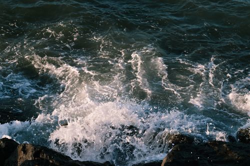 Free Dynamic waves crashing onto the rocky shore at Samsun, Türkiye, creating a powerful ocean scene. Stock Photo