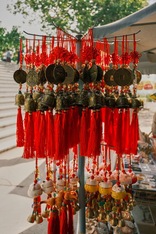 Free Colorful traditional Chinese charms with red tassels displayed at a market stall. Stock Photo