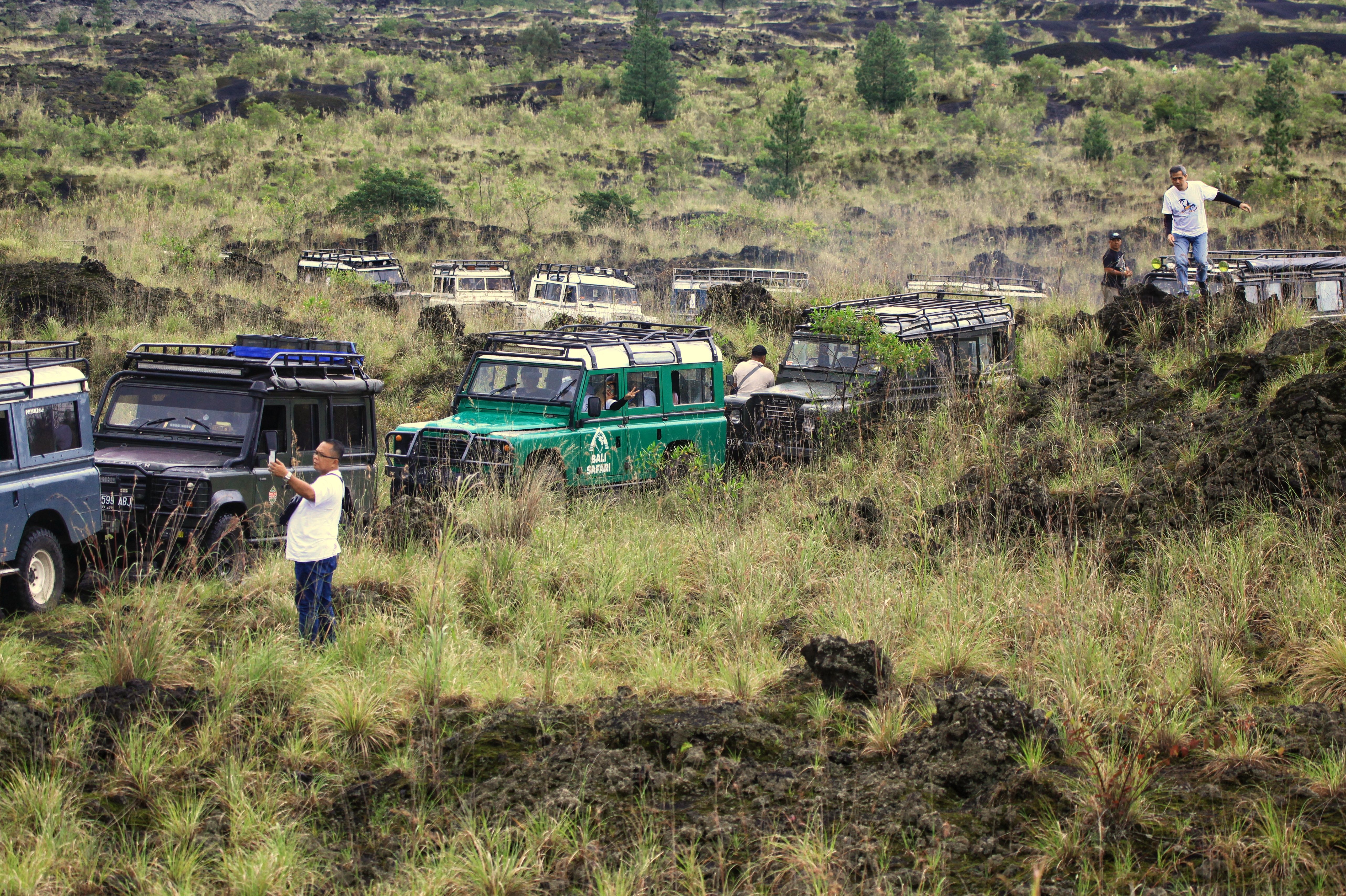 Jeeps navigating a rugged volcanic landscape in Bali, Indonesia, showcasing adventure tourism.
