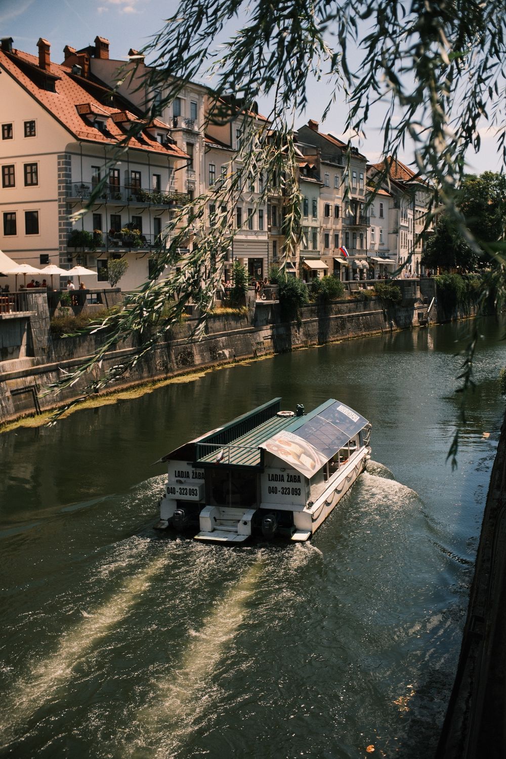 Barcă turistică pe râul Ljubljanica, între malurile cu terase