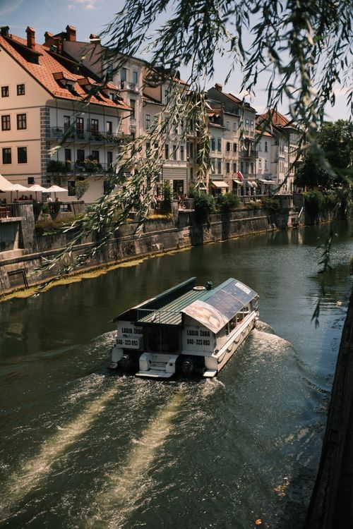 Free A picturesque view of a tourist boat cruising through the historic channel in Ljubljana, Slovenia. Stock Photo