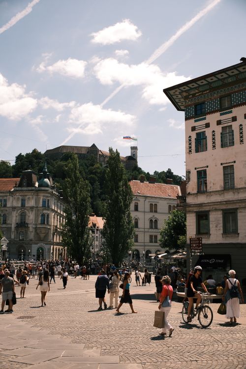 Free A busy day in a city square of Ljubljana, Slovenia, with Ljubljana Castle in the background. Stock Photo