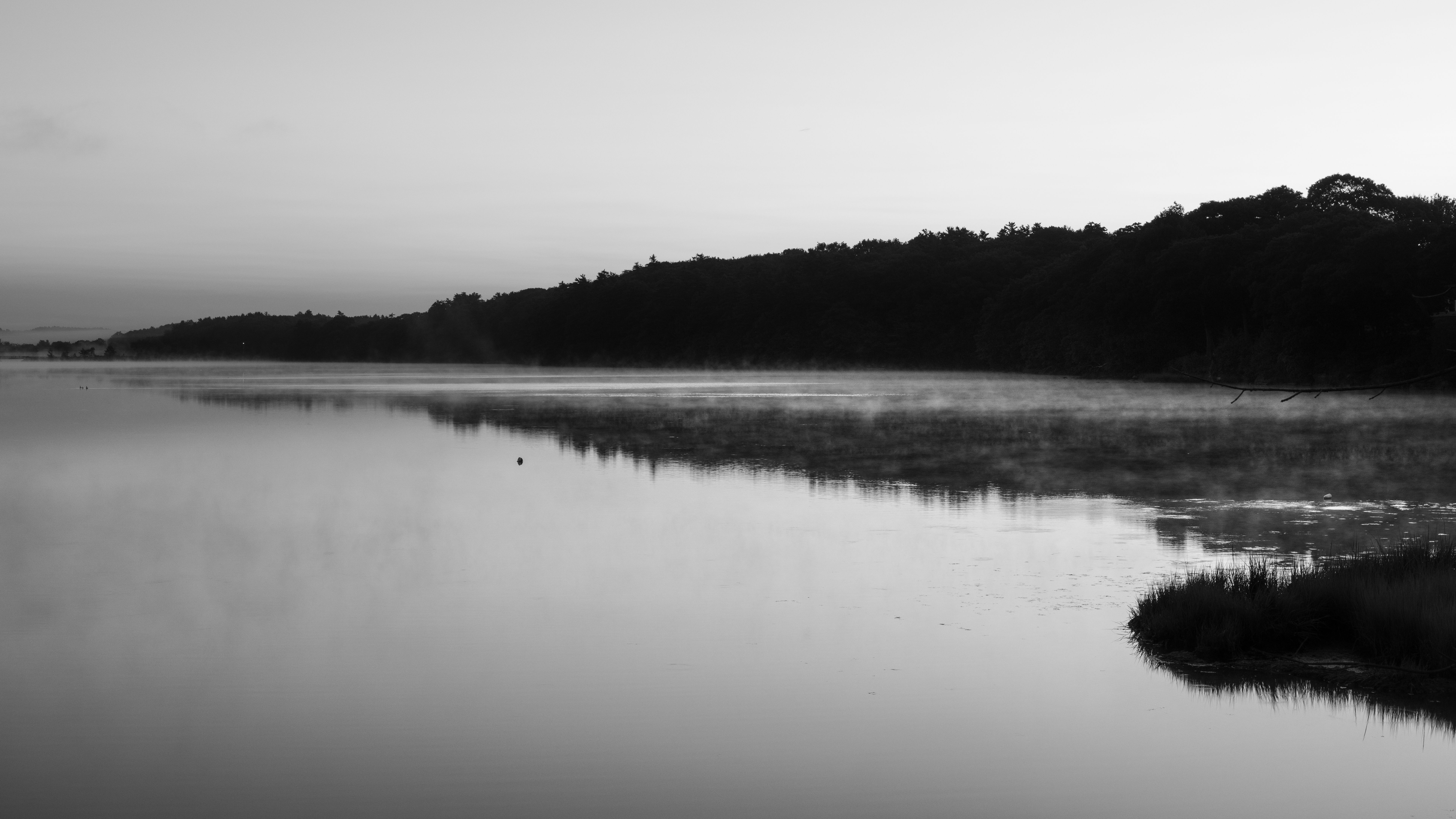 Black and white photo of a misty river at sunrise in Brunswick, Maine, USA, creating a tranquil scene.