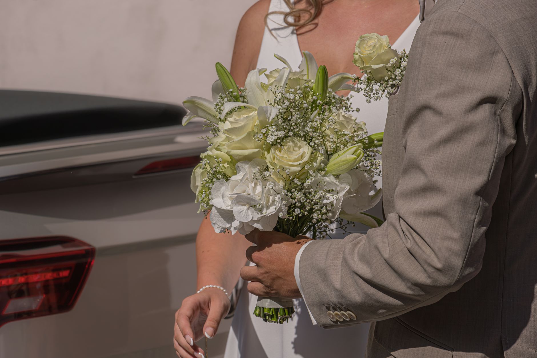 A bride holds a beautiful white floral bouquet, symbolizing elegance and love.