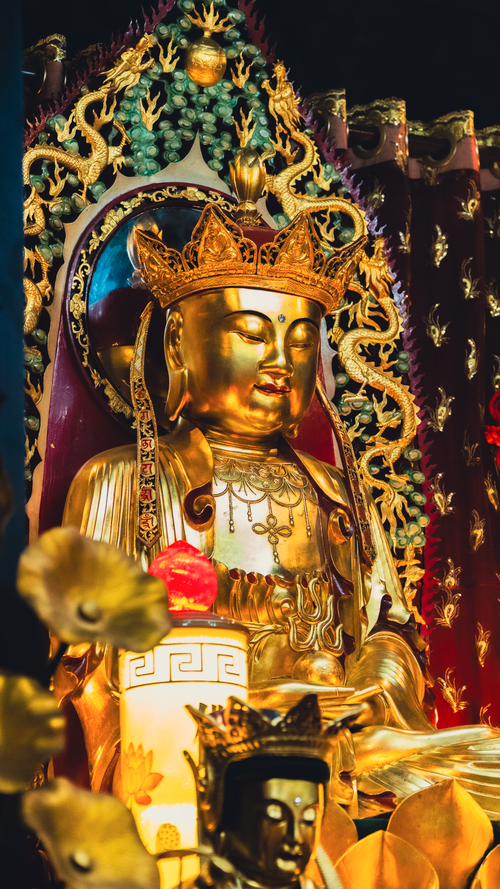 Free A detailed golden statue of Buddha in an ornate temple atmosphere, showcasing spiritual art. Stock Photo