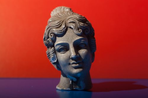 Free Classical sculpture bust with dramatic lighting on contrasting vivid background. Stock Photo