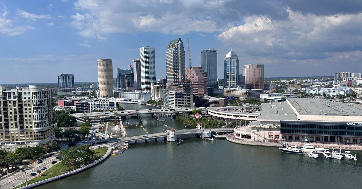 Stunning aerial view of downtown Tampa's skyline along the waterfront under a bright daytime sky.