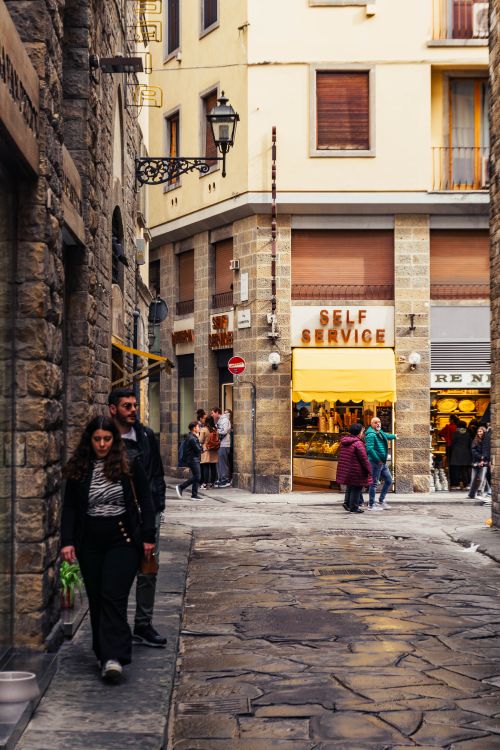 Free Capturing a bustling street scene in Florence's charming alleys with locals and tourists. Stock Photo