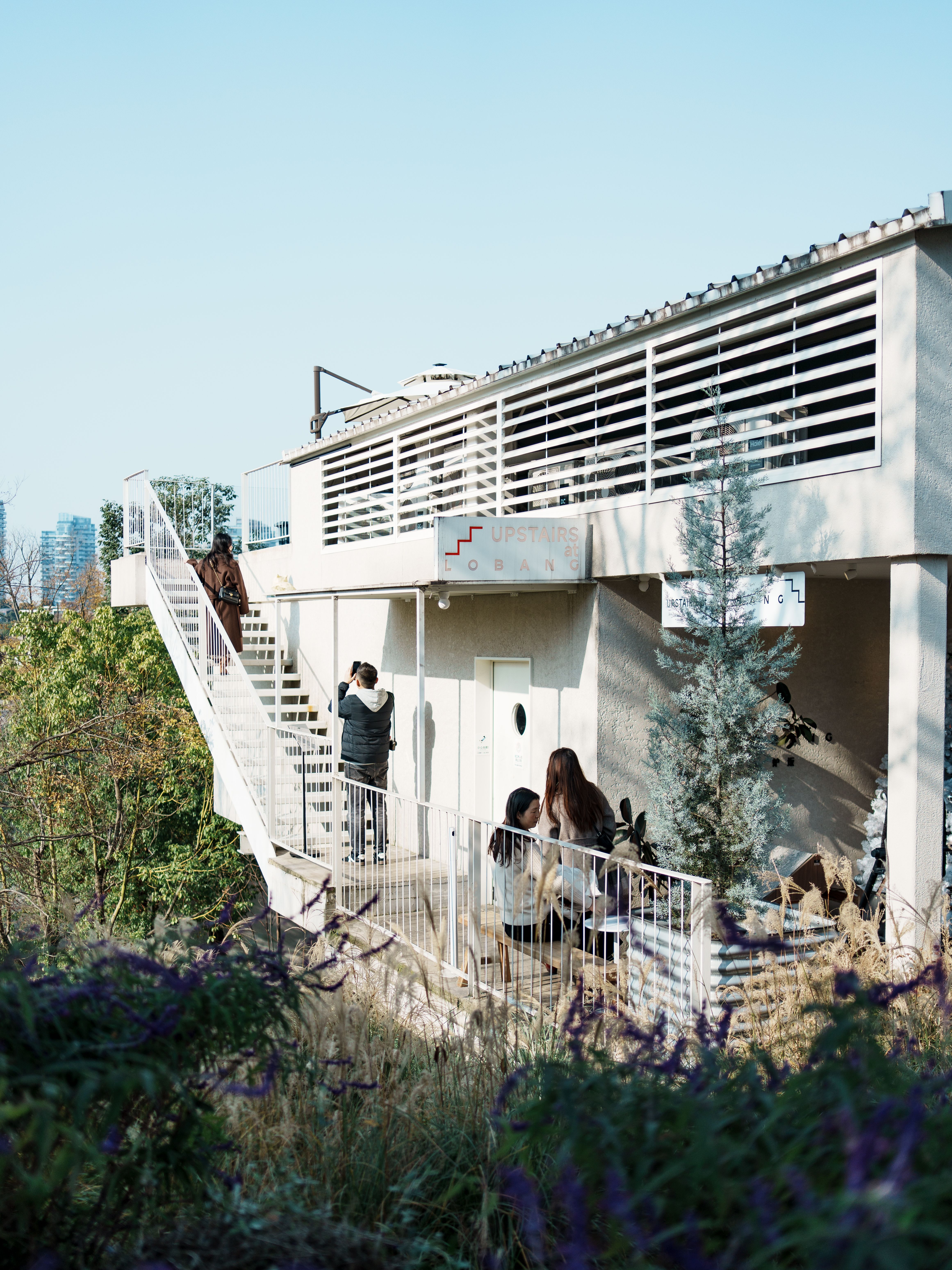Contemporary architecture with outdoor seating and people in Chengdu, China on a sunny day.