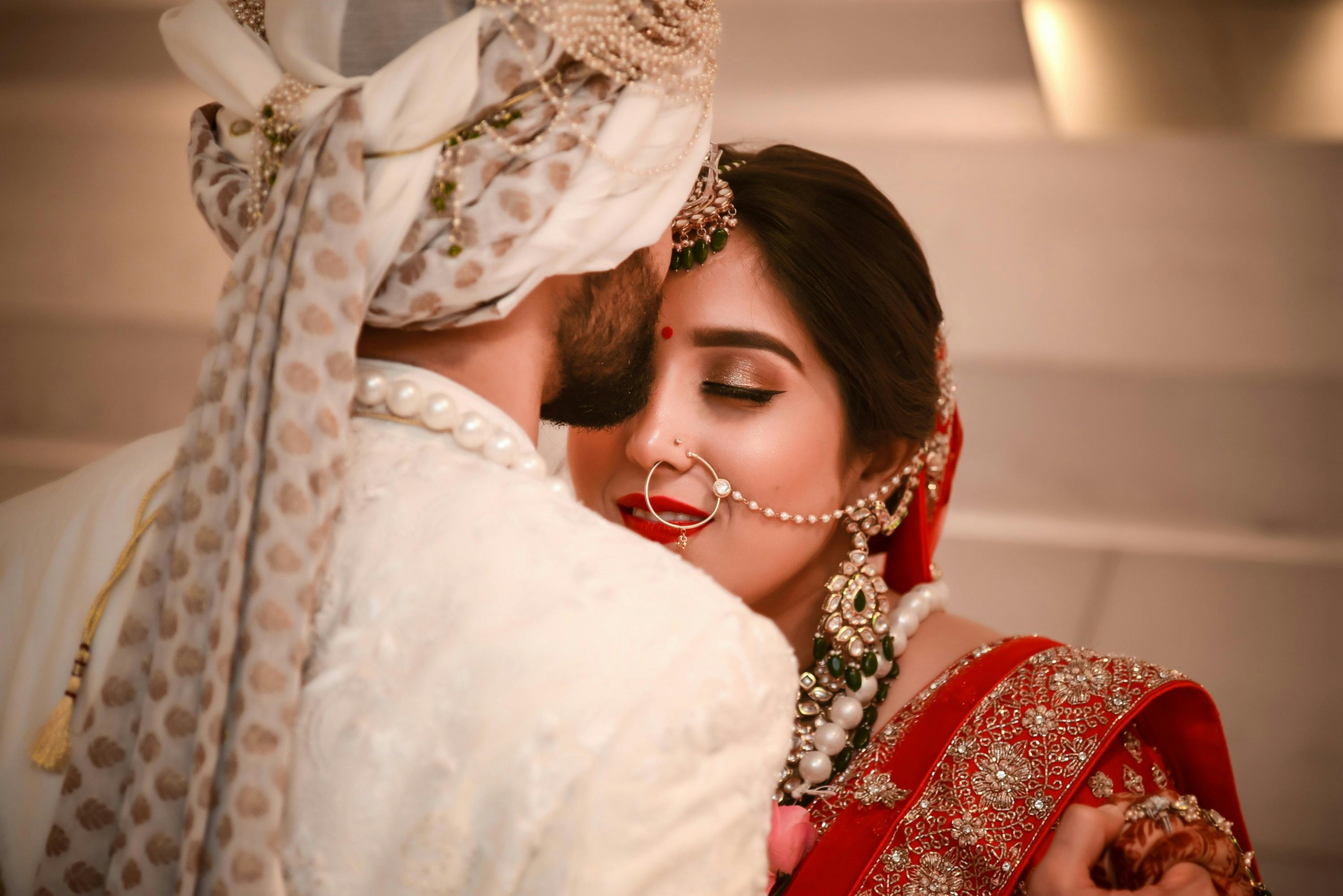 A romantic moment captured between a couple in traditional Indian wedding attire, showcasing love and commitment.