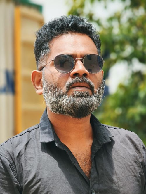Free Portrait of a confident man wearing sunglasses standing outdoors in Coimbatore, India. Stock Photo
