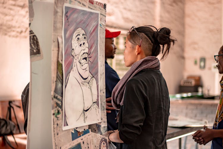 Ethnic Woman Observing Creative Portrait On Exhibition