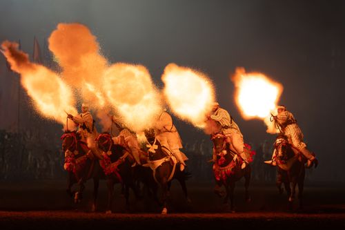 Free Five horsemen in traditional attire execute a stunning fire performance during a cultural night event. Stock Photo