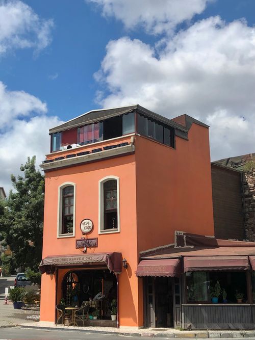 Free A vibrant orange cafe in Istanbul captures the essence of local architecture under a bright blue sky. Stock Photo