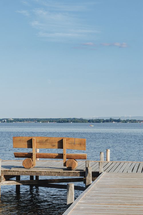Free Tranquil scene of a wooden dock and bench overlooking Lake Steinhude on a clear summer day. Stock Photo