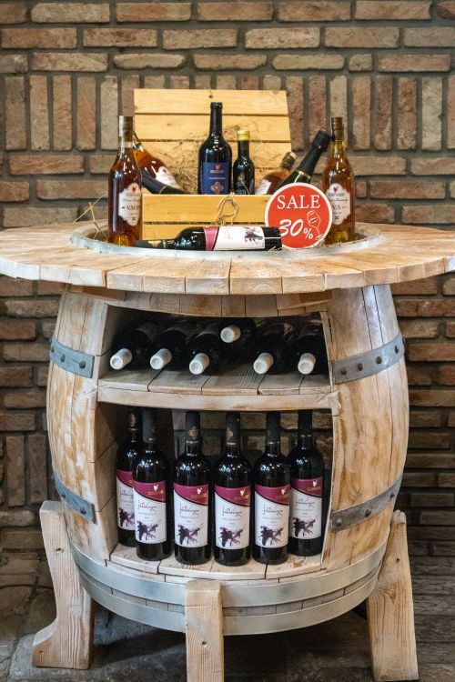 Free A rustic wooden barrel showcasing bottles of wine with a 30% sale sign. Stock Photo