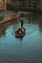 Man in Black Jacket Riding on Brown Boat on Water