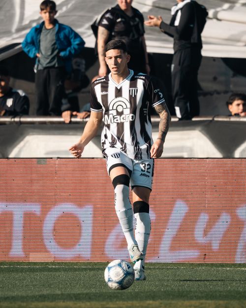 Free Soccer player in action with ball and spectators in the background during a game. Stock Photo