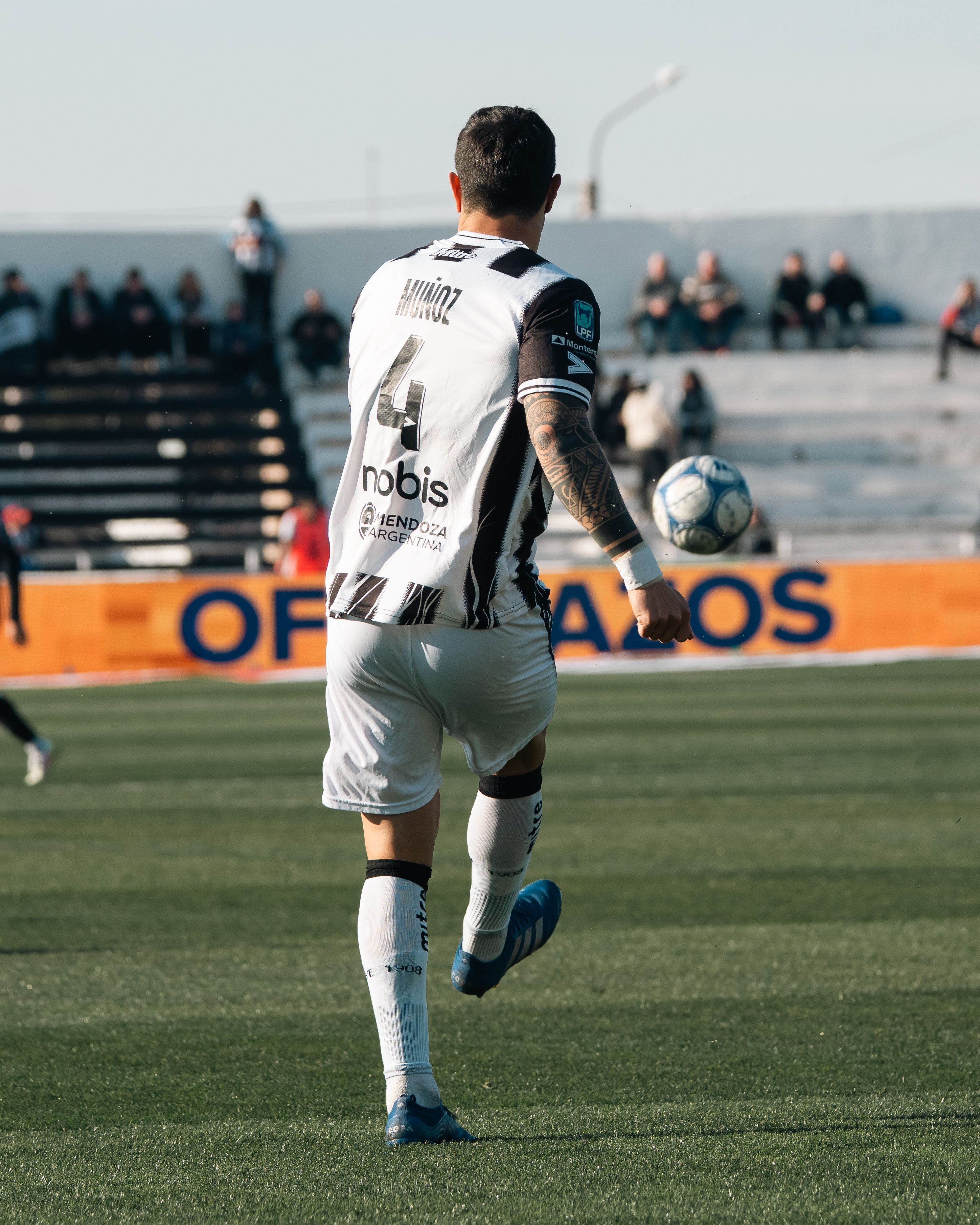 Football player in action on the field during a match, wearing white jersey.