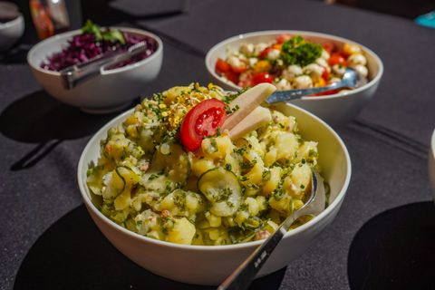 Potato salad garnished with fresh herbs — photo by Lydia Burkert on Pexels