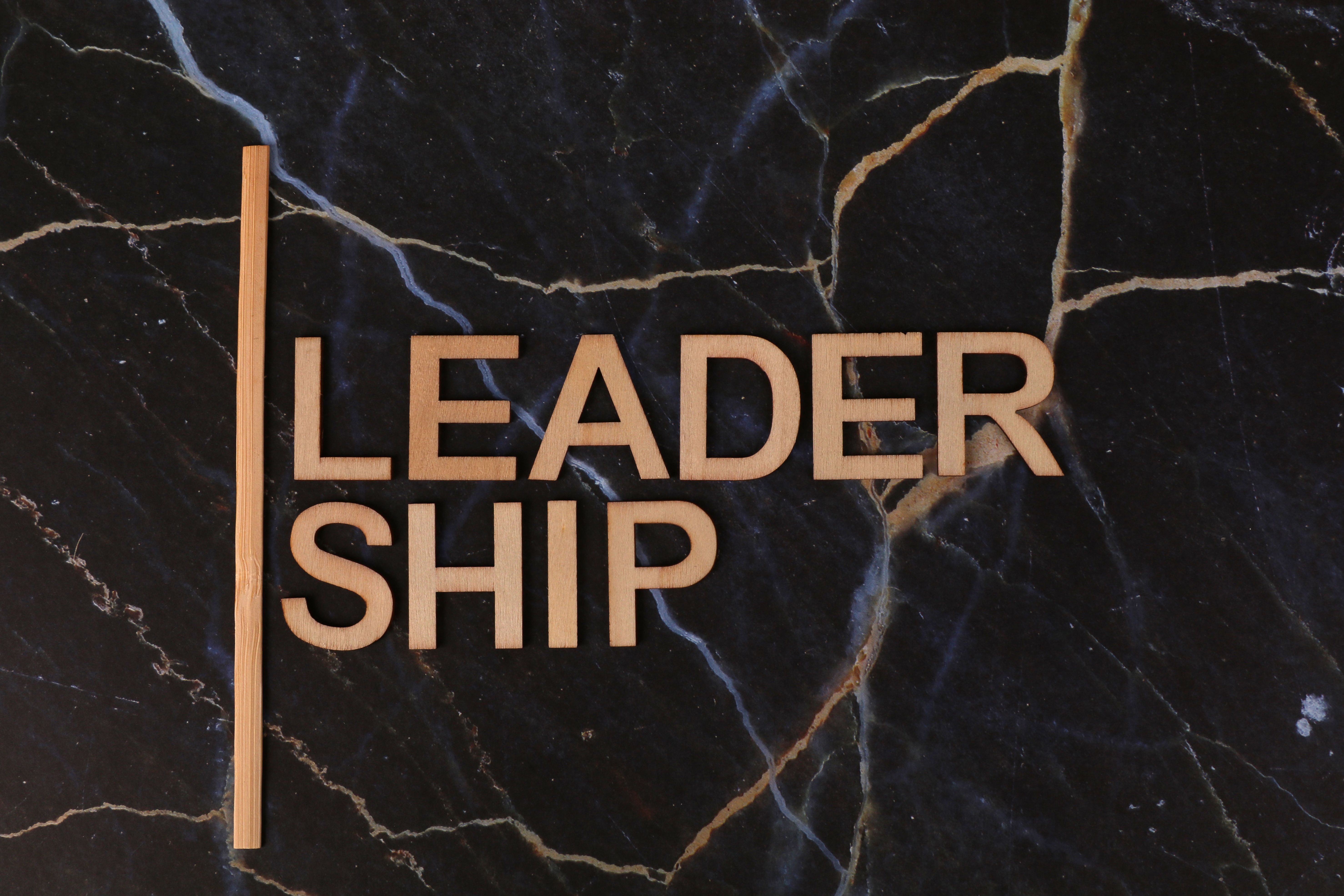 Wooden letters spelling 'Leadership' on a dark marble surface, symbolizing strength and elegance.