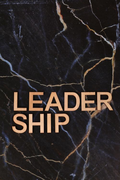 Free Wooden 'Leadership' text on a dark marble background, highlighting empowerment and business themes. Stock Photo
