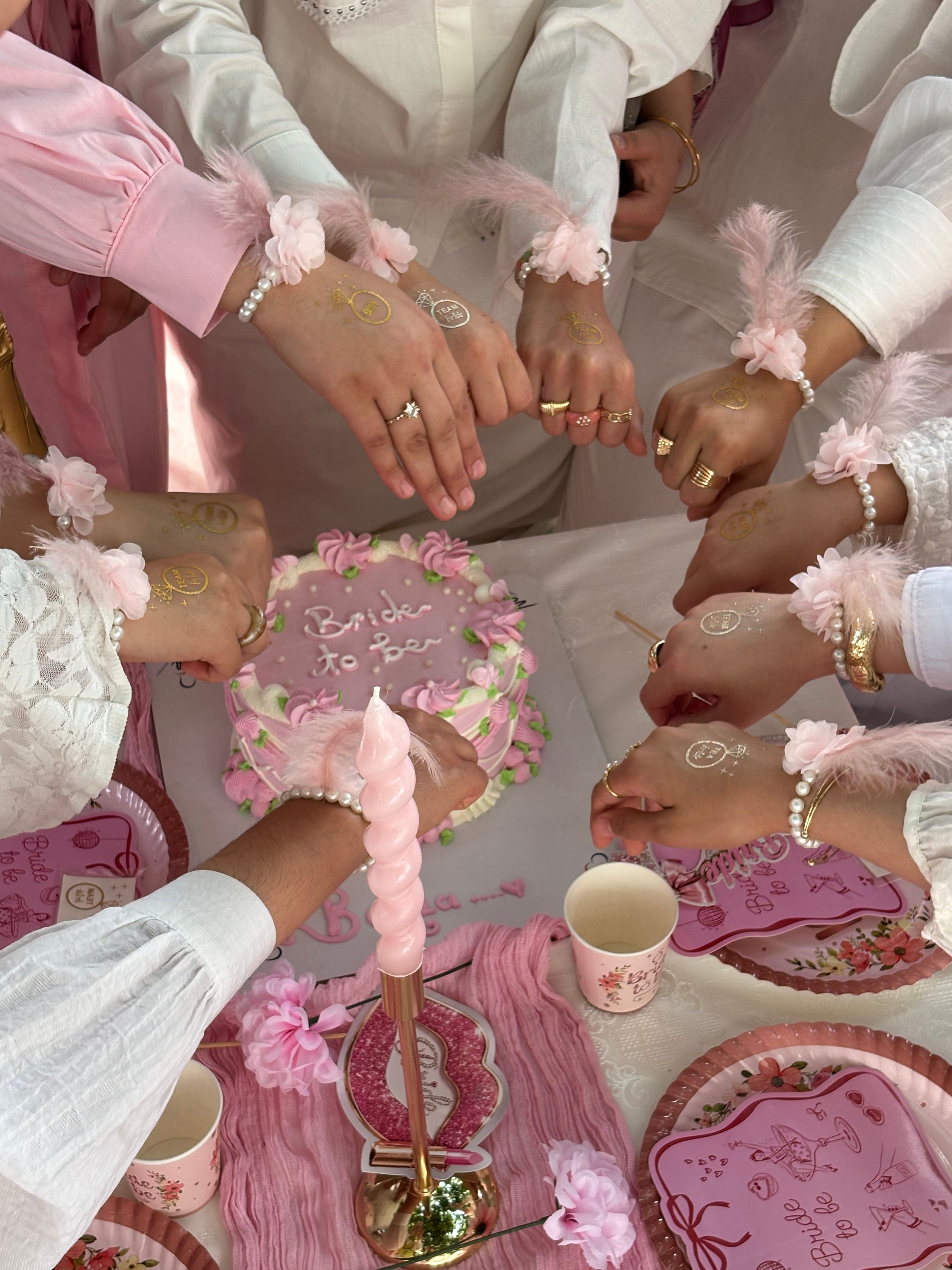 Group of friends at a bachelorette party with cake and decorations.