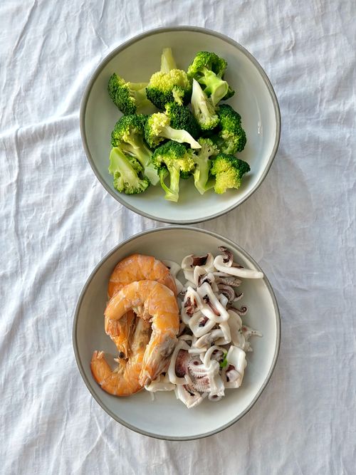 Free Two bowls with broccoli, shrimp, and squid on a white cloth. Stock Photo