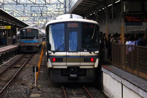 Free Commuter trains at a crowded station platform in Kyoto, Japan on a busy day. Stock Photo
