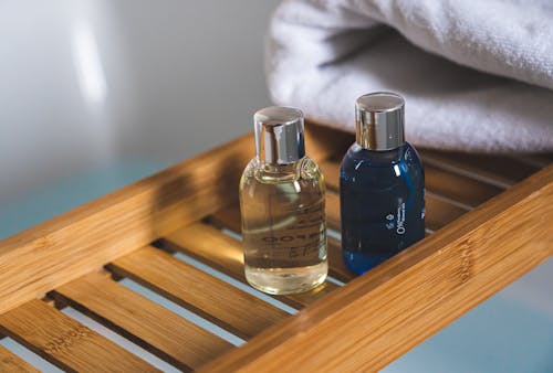 Three Blue Glass Bottles on Brown Wooden Table